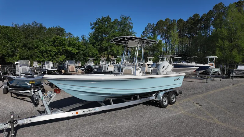 Slide: The Image of 2025 Bulls Bay 2200XS boat on trailer in outdoor lot, surrounded by trees and other boats. - 4
