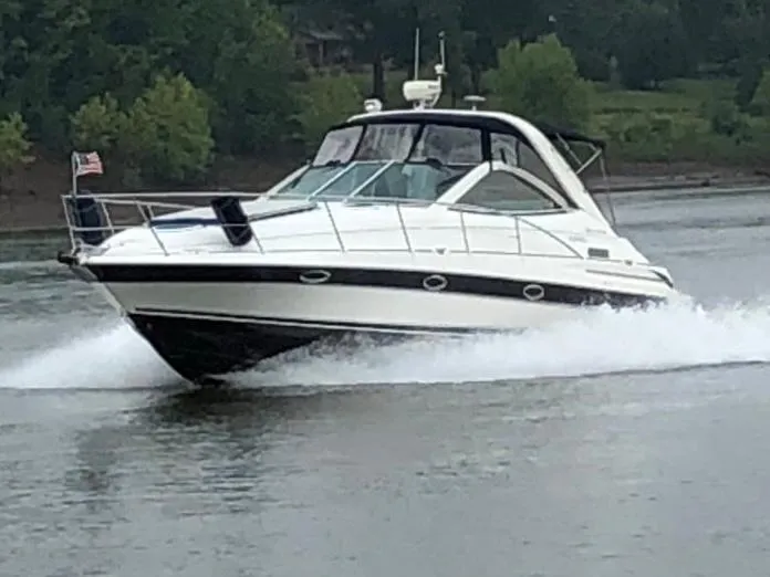 Slide: The Image of 2004 Doral Boca Grande 36 cruising on a lake with lush green surroundings. - 1