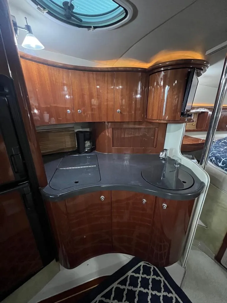 Slide: The Image of 2004 Doral Boca Grande 36 yacht interior with sleek wooden cabinetry and modern kitchenette. - 24