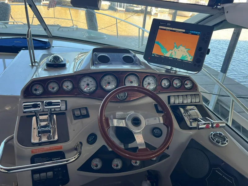 Slide: The Image of 2004 Doral Boca Grande 36 boat dashboard with steering wheel, gauges, and navigation screen. - 6