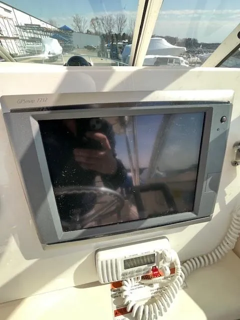 Slide: The Image of 2003 Pursuit 2870 Walkaround boat dashboard with electronic display and controls. - 11