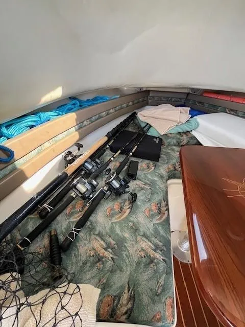 Slide: The Image of 2003 Pursuit 2870 Walkaround cabin with fishing rods and gear. - 17