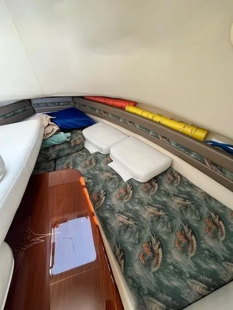 Slide: The Image of 2003 Pursuit 2870 Walkaround cabin interior with patterned cushions and colorful storage. - 18