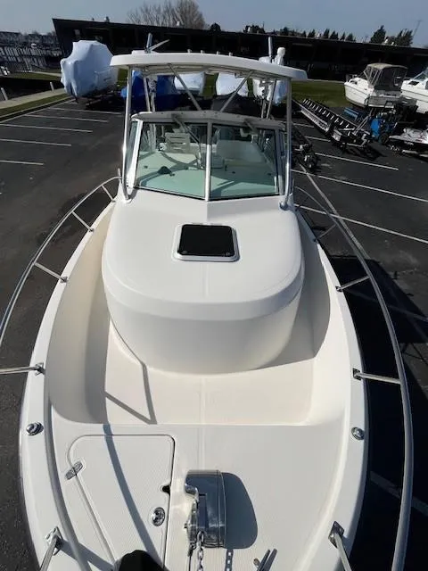 Slide: The Image of 2003 Pursuit 2870 Walkaround boat, docked, showcasing spacious deck and sleek design. - 23