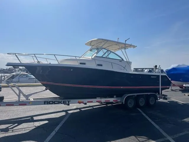 Slide: The Image of 2003 Pursuit 2870 Walkaround boat on a trailer in a parking lot. - 5