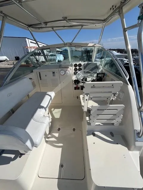 Slide: The Image of 2003 Pursuit 2870 Walkaround boat interior with helm and seating area. - 9