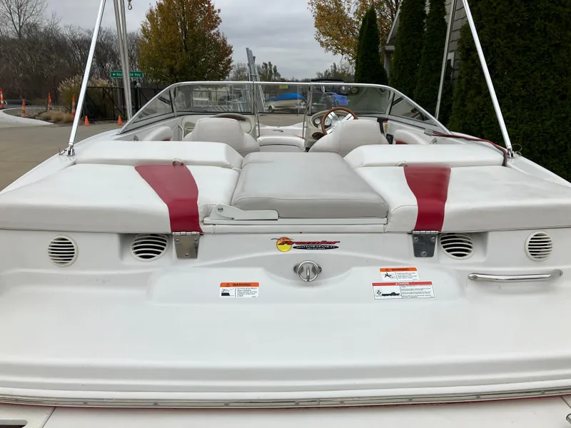 Slide: The Image of 2011 Glastron GT 205 boat, rear view, white with red accents, parked outdoors. - 5