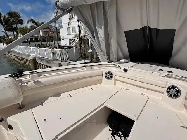 Slide: The Image of 2024 Grady-White Canyon 336 boat interior with seating and speakers, docked near waterfront homes. - 10