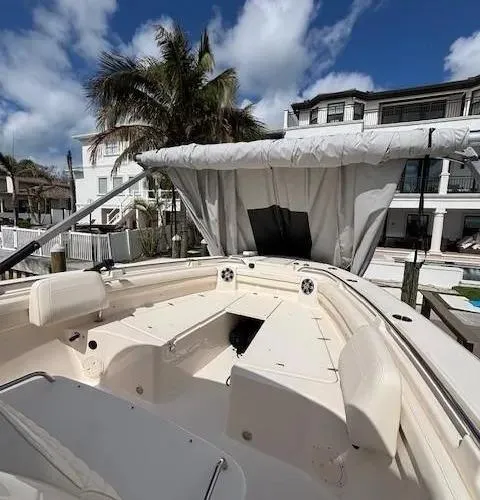 Slide: The Image of 2024 Grady-White Canyon 336 boat with canopy, docked near palm trees and buildings. - 11