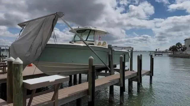 Slide: The Image of 2024 Grady-White Canyon 336 boat docked under cloudy sky. - 2