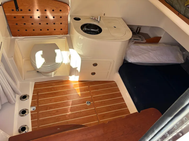 Slide: The Image of 2024 Grady-White Canyon 336 cabin interior with wood flooring, sink, and bed. - 28