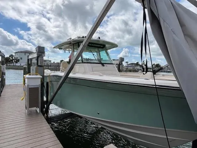 Slide: The Image of 2024 Grady-White Canyon 336 boat docked under cloudy sky. - 3