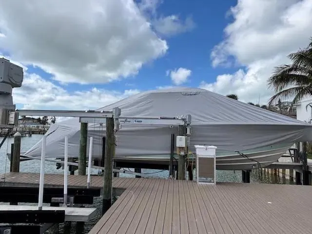Slide: The Image of 2024 Grady-White Canyon 336 boat covered at dock, under cloudy sky. - 5