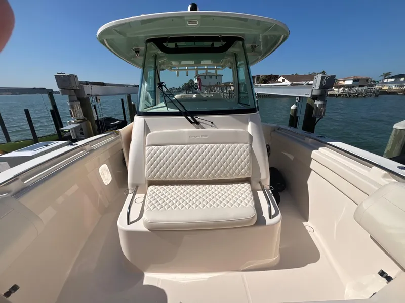 Slide: The Image of 2024 Grady-White Canyon 336 boat with cushioned seating, docked by the water. - 6