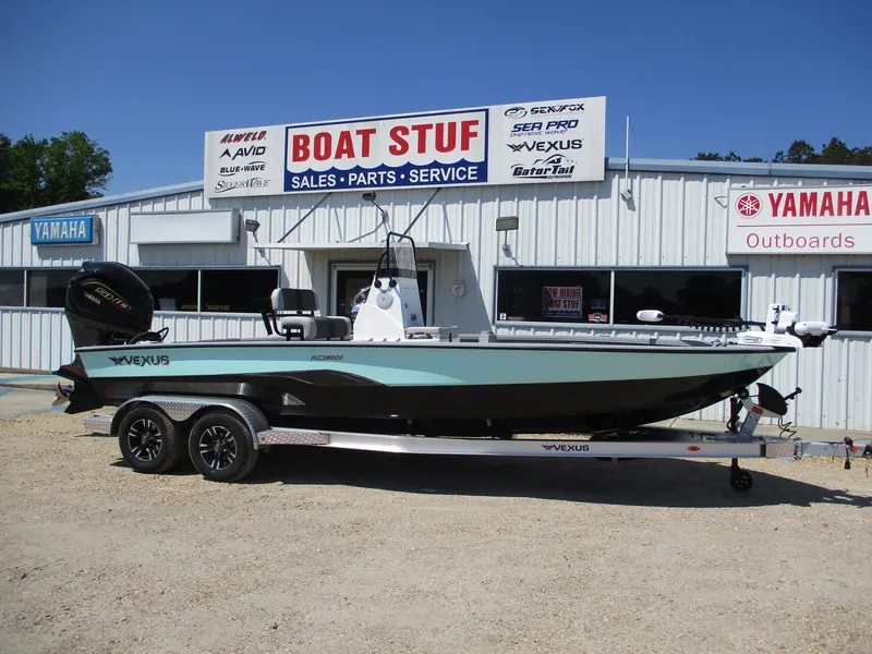 Slide: The Image of 2025 Vexus ACX 2210 boat displayed at dealership, featuring sleek design and dual-axle trailer. - 0