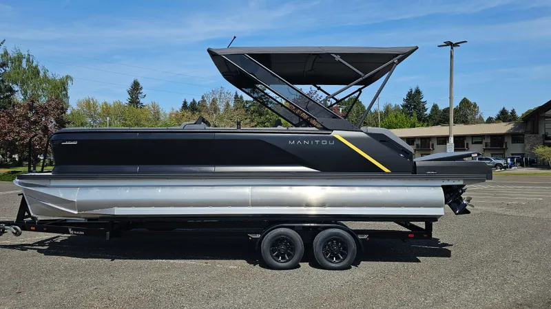 Slide: The Image of 2025 Manitou 24' Explore MAX Deck Navigator with 150hp Rotax Stealth Motor on trailer. - 2