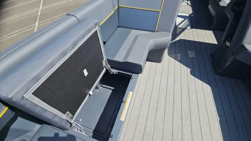 Slide: The Image of 2025 Manitou 24' Explore MAX Deck Navigator with open storage compartment and sleek seating. - 23