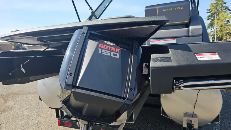 Slide: The Image of 2025 Manitou 24' Explore MAX with 150hp Rotax Stealth Motor, rear view. - 24