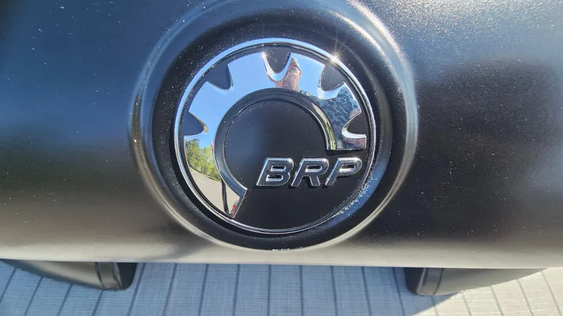 Slide: The Image of BRP logo on 2025 Manitou 24' Explore MAX Deck Navigator boat. - 25