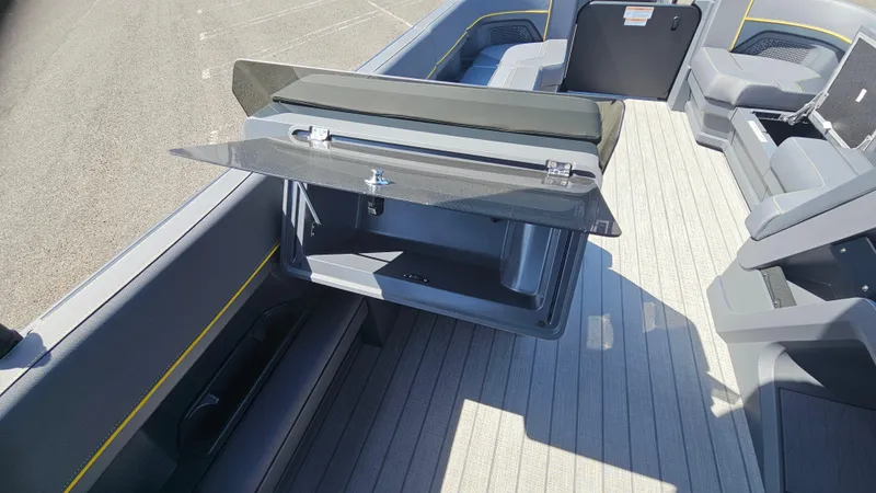 Slide: The Image of 2025 Manitou 24' Explore MAX Deck Navigator interior with open storage compartment. - 38