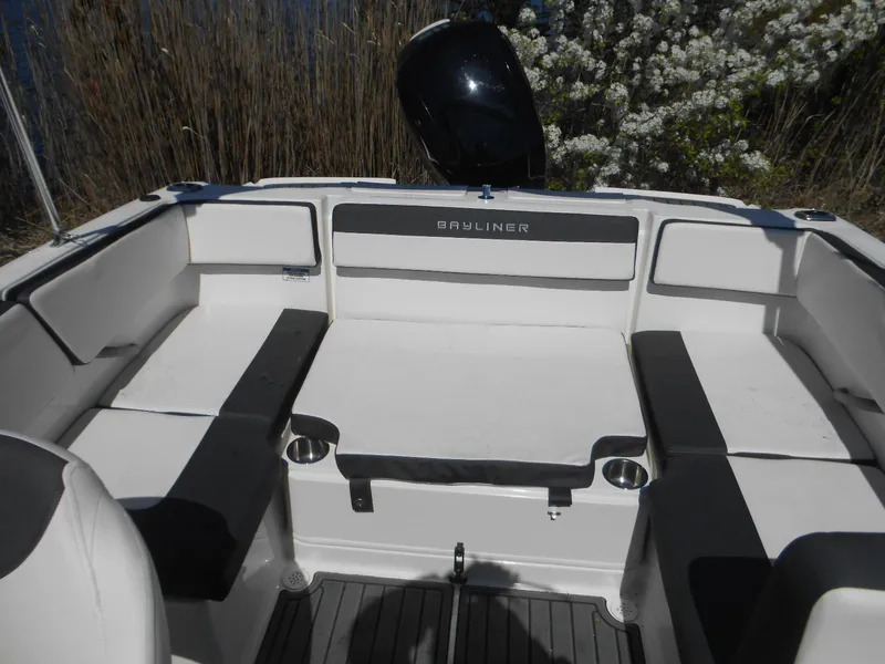Slide: The Image of 2022 Bayliner VR4 Bowrider OB interior with seating and motor, surrounded by nature. - 6