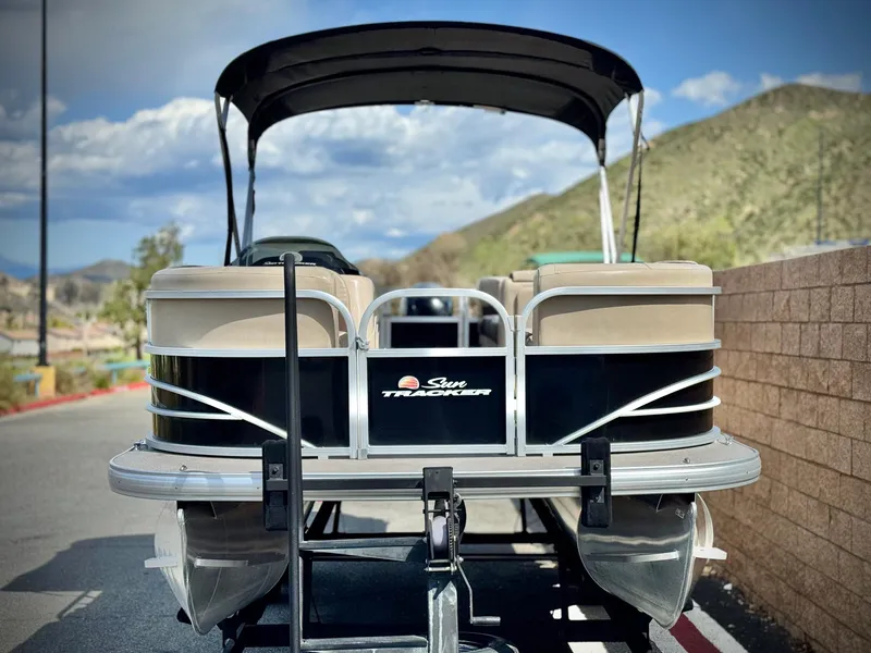 Slide: The Image of 2018 Sun Tracker Party Barge 22 DLX pontoon boat on trailer, scenic mountain backdrop. - 2