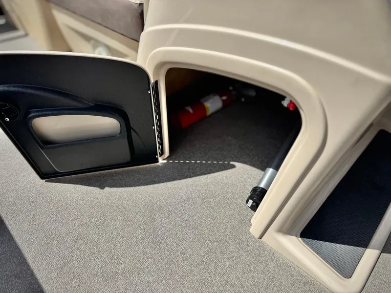 Slide: The Image of Open storage compartment on 2018 Sun Tracker Party Barge 22 DLX with fire extinguisher inside. - 22