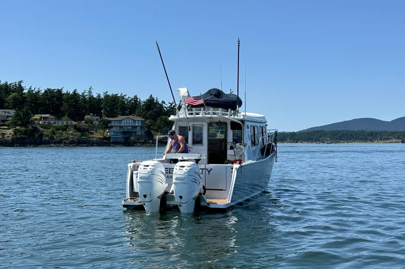 Slide: The Image of 2020 Coastal Craft 33 ProFish boat on calm water, scenic coastal backdrop. - 11