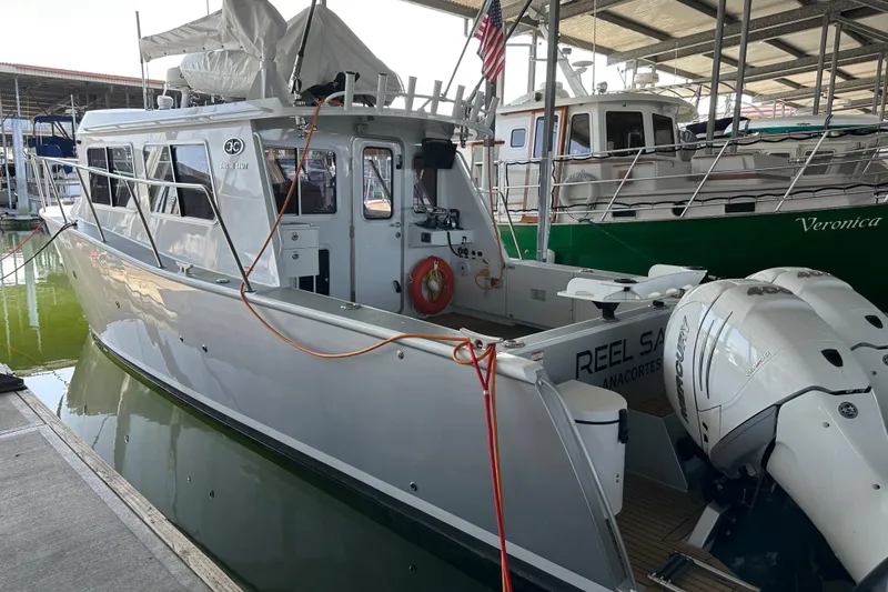 Slide: The Image of 2020 Coastal Craft 33 ProFish boat docked in marina, featuring sleek design and powerful outboard motor. - 16