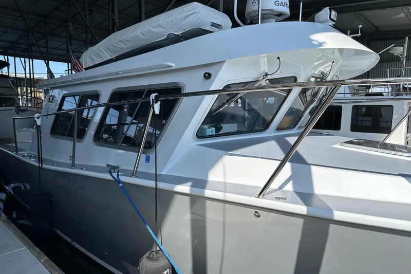 Slide: The Image of 2020 Coastal Craft 33 ProFish boat docked in a marina under a covered structure. - 19