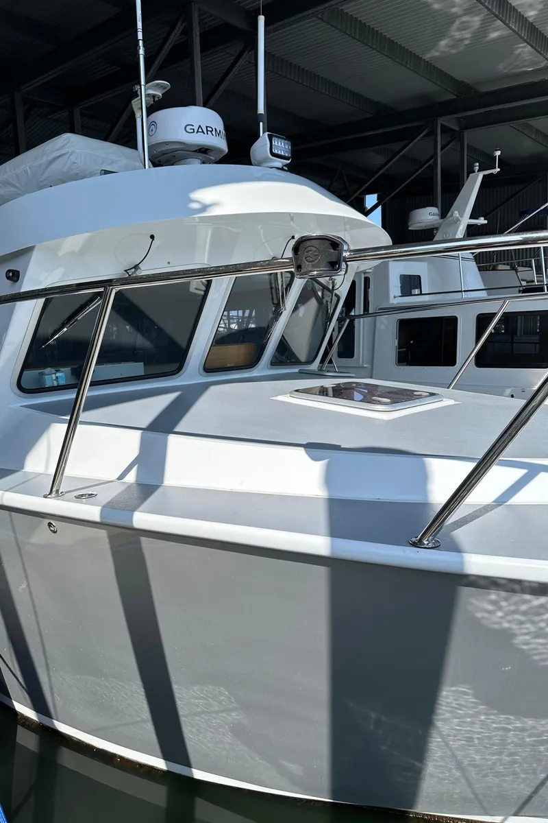 Slide: The Image of 2020 Coastal Craft 33 ProFish boat docked in a marina under a metal roof. - 20
