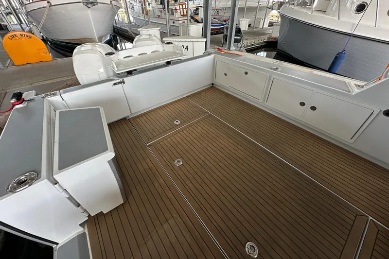 Slide: The Image of 2020 Coastal Craft 33 ProFish boat deck with wood finish and storage compartments. - 23