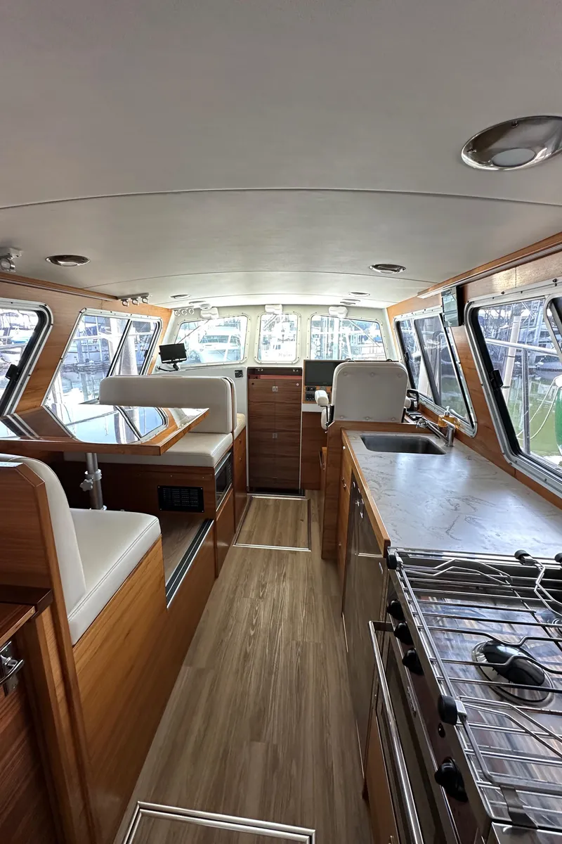 Slide: The Image of 2020 Coastal Craft 33 ProFish interior with wood finish, seating, and kitchen area. - 26