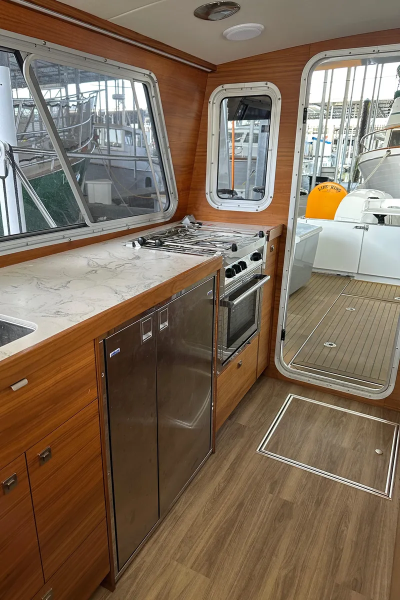 Slide: The Image of Interior of 2020 Coastal Craft 33 ProFish with modern kitchen and wood finish. - 33