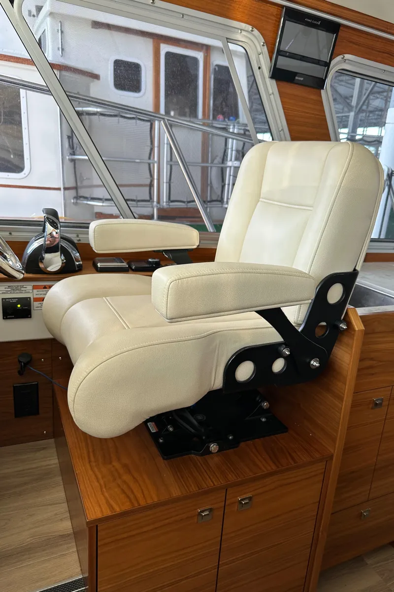 Slide: The Image of Captain's chair in 2020 Coastal Craft 33 ProFish boat interior, featuring luxurious design and wood accents. - 38