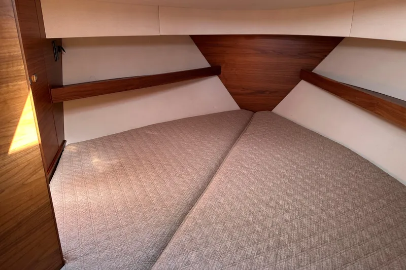 Slide: The Image of 2020 Coastal Craft 33 ProFish cabin interior with wood accents and beige bedding. - 43