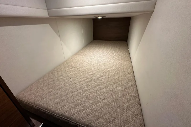 Slide: The Image of 2020 Coastal Craft 33 ProFish cabin interior with a cozy bed and soft lighting. - 51