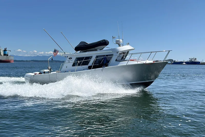 Slide: The Image of 2020 Coastal Craft 33 ProFish boat cruising on open water under clear blue sky. - 9