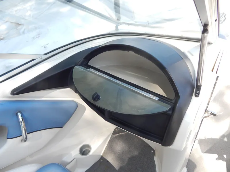 Slide: The Image of Interior view of 2013 Bayliner 235 Bowrider boat, featuring dashboard and seating area. - 12