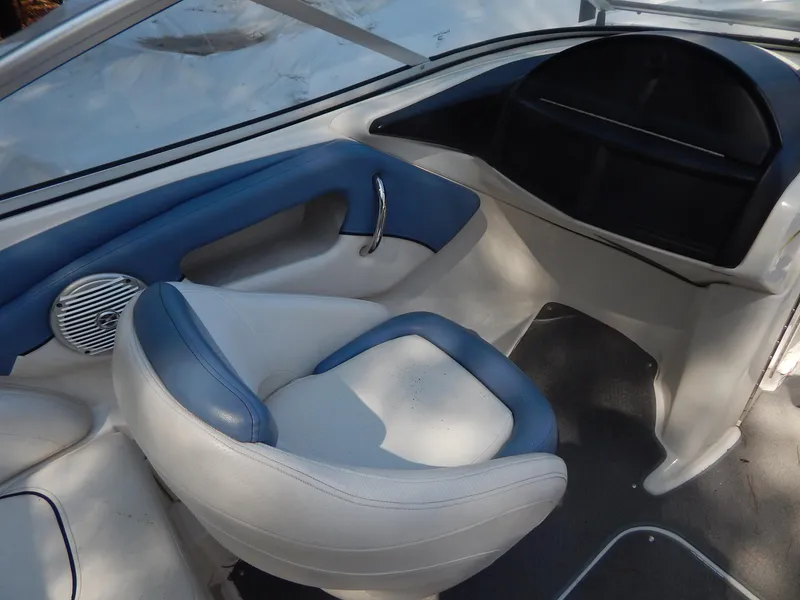 Slide: The Image of 2013 Bayliner 235 Bowrider interior with blue and white seating and dashboard. - 19