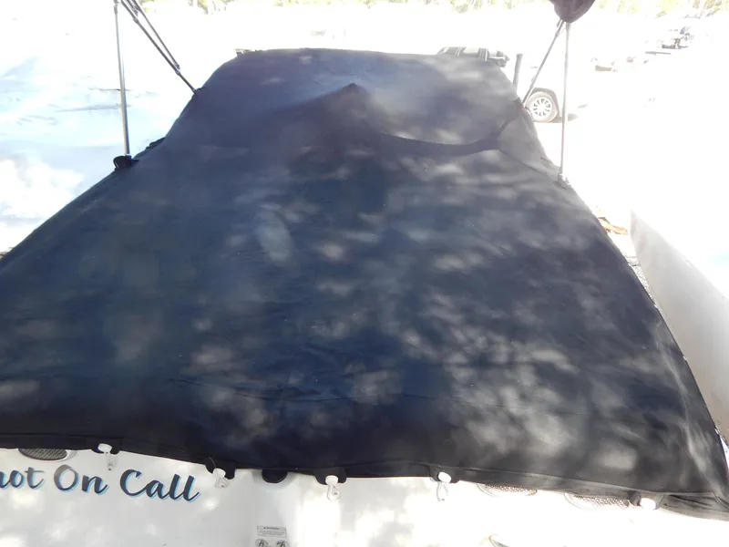 Slide: The Image of 2013 Bayliner 235 Bowrider with black cover, parked outdoors. - 29