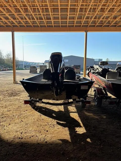 Slide: The Image of 2025 Lowe Skorpion 17 boat under a wooden canopy, rear view. - 3