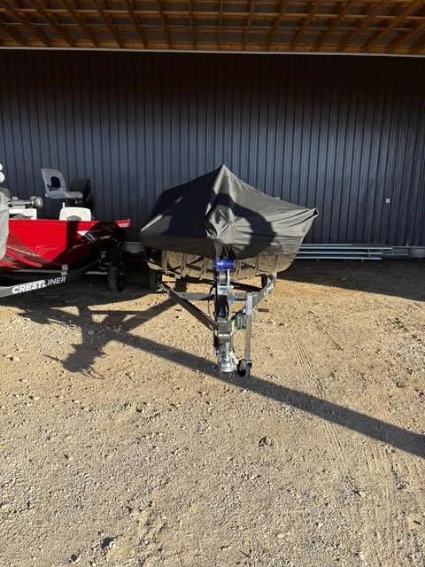 Slide: The Image of 2025 Lowe Skorpion 17 boat covered, parked on a trailer in a sunny outdoor setting. - 4