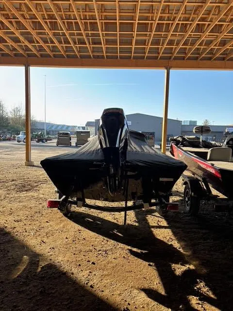 Slide: The Image of 2025 Lowe Skorpion 17 boat under a wooden shelter, partially covered. - 8