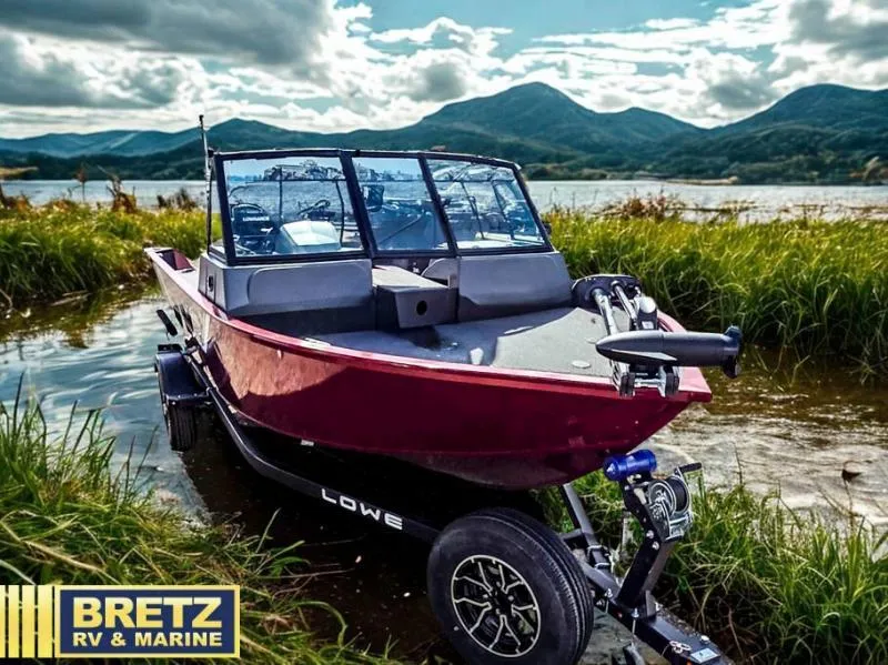 Slide: The Image of Red boat on trailer by lake, mountains in background, Bretz RV & Marine logo. - 1