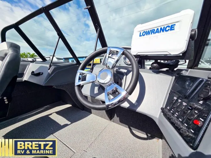 Slide: The Image of Boat cockpit with steering wheel, Lowrance navigation system, and Bretz RV & Marine branding. - 12