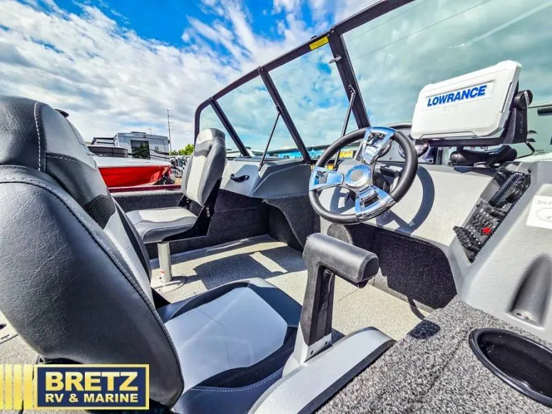 Slide: The Image of Interior of 2025 Machine Walk Thru FM 1625 WT boat with steering wheel and seats. - 14