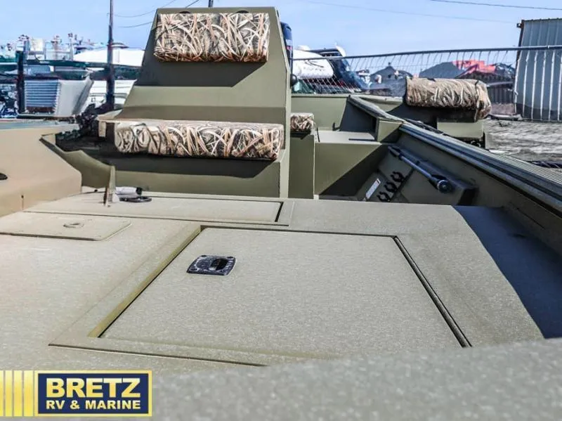 Slide: The Image of 2025 Roughneck RX1860 Tunnel Jet boat interior with camo seating, displayed at Bretz RV & Marine. - 15