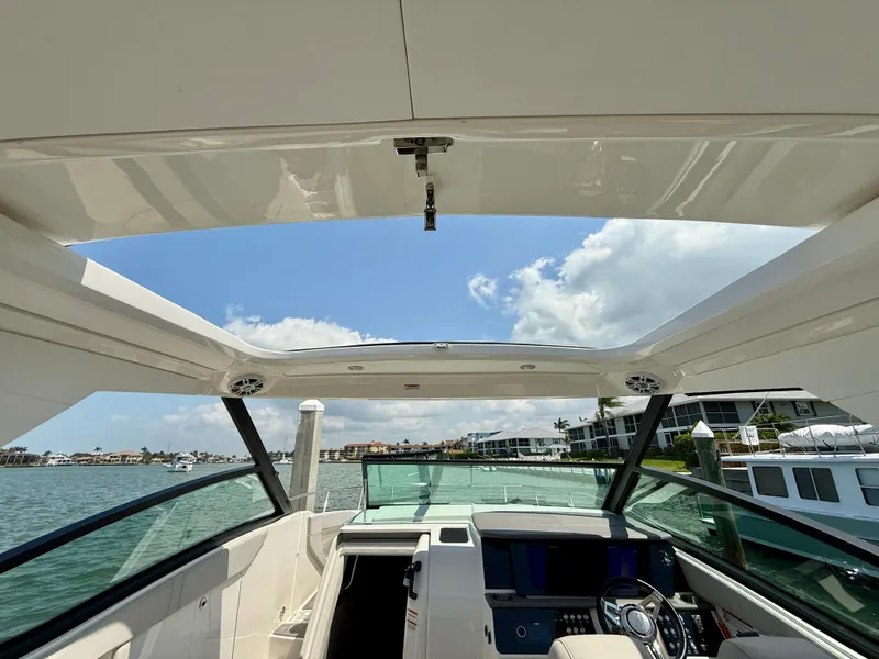 Slide: The Image of 2022 Sea Ray Sundancer 320 OB boat interior with open sunroof, overlooking water and sky. - 3