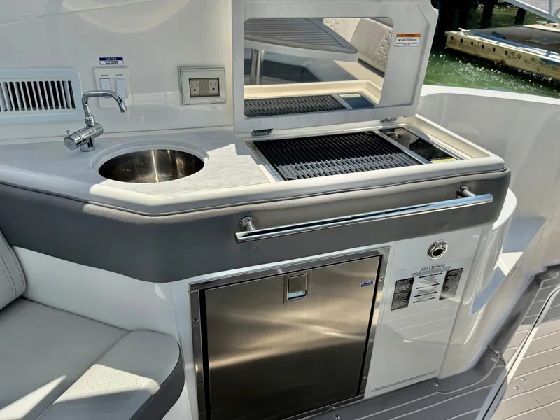 Slide: The Image of Outdoor kitchenette on 2022 Sea Ray Sundancer 320 OB with sink, grill, and fridge. - 4